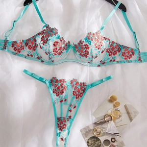 Flat lay of teal lace lingerie set featuring vibrant orange floral embroidery detailing