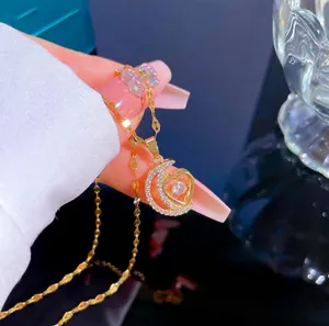 Detail of gold-plated moon and heart pendant necklace with micro-paved cubic zirconia