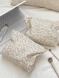 Floral corduroy cosmetic bags in cream and blue colors for travel makeup storage