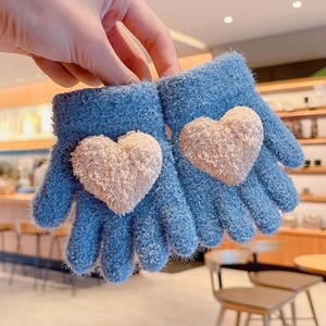 Winter knitted kids gloves in blue with a large beige plush heart pattern