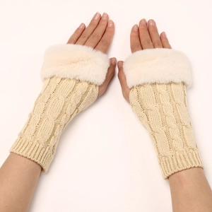 Detail of cable knit texture and faux fur trim on beige fingerless wrist warmers