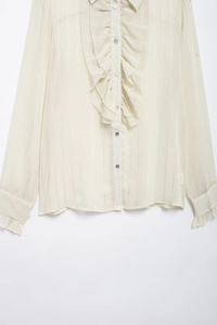 Detailed view of cream semi-transparent blouse with gold vertical stripes and ruffles
