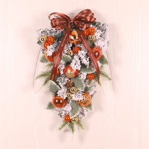 Detail of Christmas teardrop swag with flocked pine needles and orange festive balls