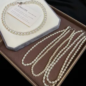 Elegant tiered pearl necklace set with round and oval beads on a display tray
