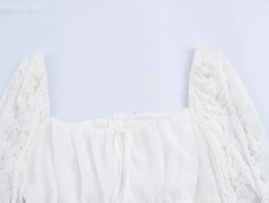 Detail of square neckline with lace patchwork and ruched front on white mini dress