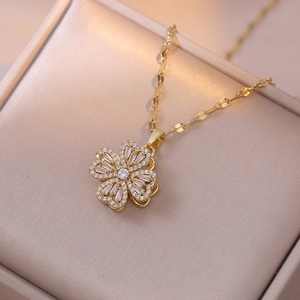 Macro shot of gold four-leaf clover pendant with sparkling cubic zirconia on jewelry box