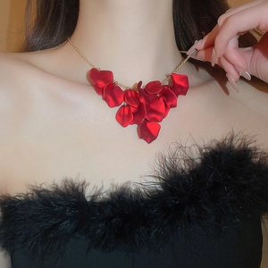 Close-up of elegant red petal tassel necklace with gold chain worn on model's neck