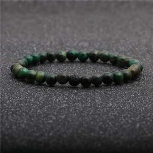 Detail of green tiger eye beads and black lava stone on a beaded bracelet for men