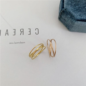 Macro detail of intertwined three-layer 18K gold plated rings on a velvet jewelry box