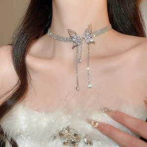 Close-up of sparkling rhinestone butterfly choker with long dangling tassels on model