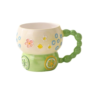 Hand-painted ceramic breakfast mug with floral patterns and a unique green beaded handle