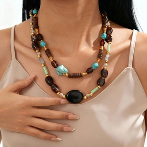Close-up of bohemian layered beaded necklace with turquoise and oval black gemstone
