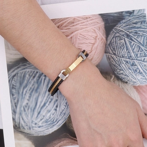 Detail of men's leather bracelet with gold wire and steel plate on blue yarn balls