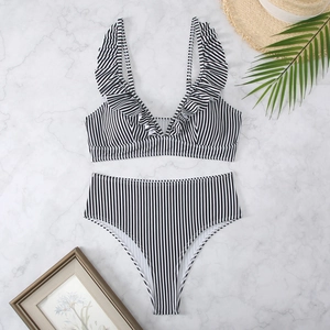 Flat lay of black and white striped bikini with V-neck ruffles and high waist bottom