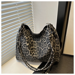 Detail shot of the knotted strap and metal ring on a leopard print tote bag