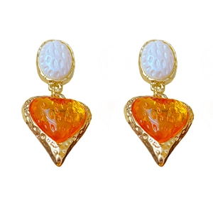 Vintage style gold earrings with white oval and orange heart textured drop pendants