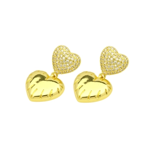 Close-up of golden double heart earrings with shimmering zircon pave on white background