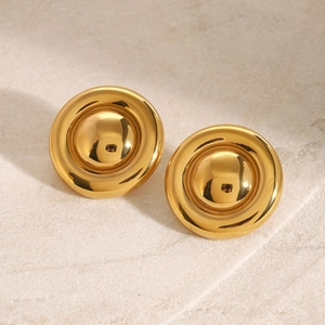 Macro shot of gold stainless steel tiered hoop earrings on a natural stone surface