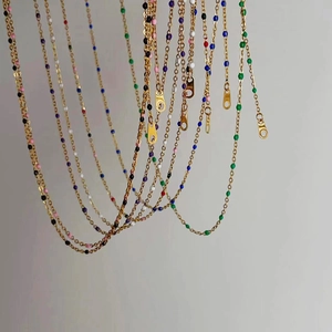Detail of colorful enamel beads on gold-plated stainless steel chains for layering