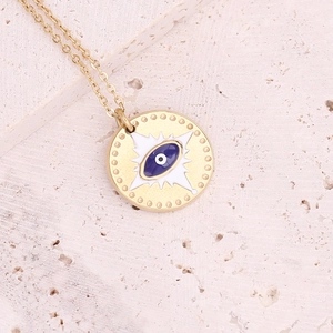 Macro view of gold evil eye pendant with blue enamel and star details on a fine chain