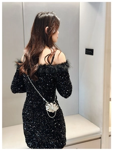 Detail shot of the black sequin dress featuring feathered off-shoulder trim and open back