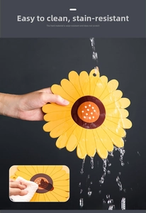 Waterproof sunflower silicone placemat being washed under running water to show easy cleaning