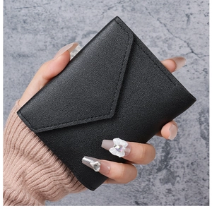 Detail der minimalistischen schwarzen Brieftasche mit Lychee-Narbenleder und Umschlagklappe