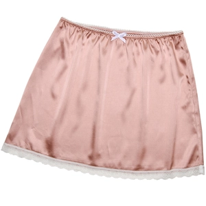 Détail d'une mini-jupe en satin rose avec bordure en dentelle blanche et petit nœud doux