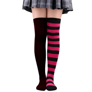 Détail de chaussettes hautes avec motifs blocs de couleur bordeaux et rayures rose noir