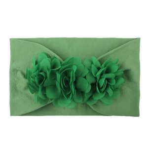 Detail of green chiffon flowers on a soft elastic nylon headband for baby girls