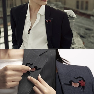 Macro detail of cat silhouette brooch with embedded pink and red dried flower petals