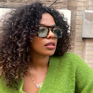 Fashionable dark tortoiseshell sunglasses with gradient lenses and a green knit top