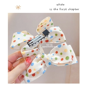 Close-up of colorful polka dot bow hair clips with a 5cm metal duckbill clip design