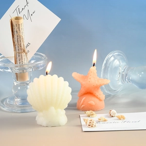 Coffret de bougies parfumées en forme de coquillage et étoile de mer sur décor marin