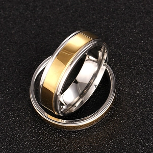 Close-up of 316L stainless steel rings in polished gold and frosted silver finishes