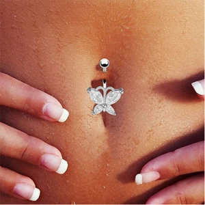 Macro shot of silver butterfly belly button ring with crystals on moist skin