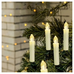 Close-up of LED flameless candle with green clip on Christmas tree branch