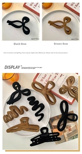 Détail de grandes pinces à cheveux floquées de 11x7cm en noir et marron forme nœud