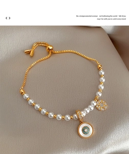 Détail d'un bracelet de perles dorées avec pendentifs tournesol sur satin champagne
