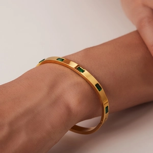 Bracelet doré en acier inoxydable orné de plusieurs zircons verts rectangulaires au poignet