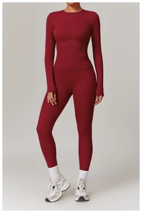 Detail of burgundy long sleeve yoga top featuring thumbholes and high-waist sports leggings