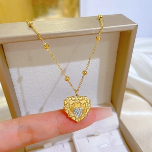 Macro view of gold heart necklace with MOM engraving and small crystal inlay