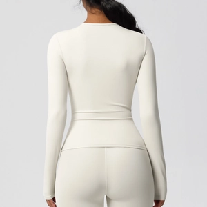 Détail du haut de sport à manches longues ivoire et leggings montrant la coupe au dos