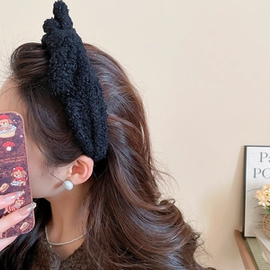Detail view of black faux fur headband featuring thick knot design on a fashion model