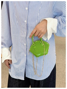 Detail of bright green beaded mini shell bag with metal chain strap and top handle