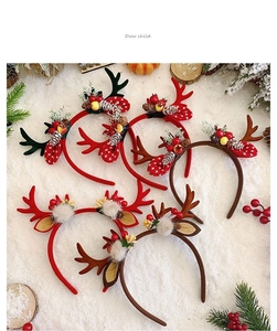 Detailed view of six plush reindeer antler headbands with berries and bells on fake snow