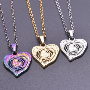 Three hollow nested heart pendants in gold, silver, and iridescent steel on fine chains