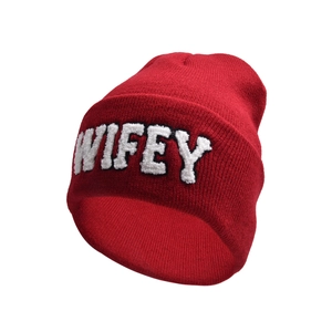 Close-up of red knitted beanie featuring white fuzzy WIFEY lettering with detailed texture