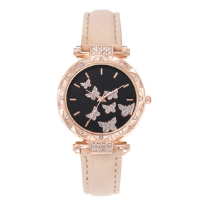 Close-up of women watch with rose gold case, beige strap and rhinestone butterfly dial