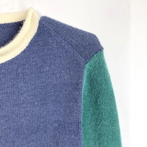 Fashionable color-block knitted sweater with blue body, green sleeves and cream round neck